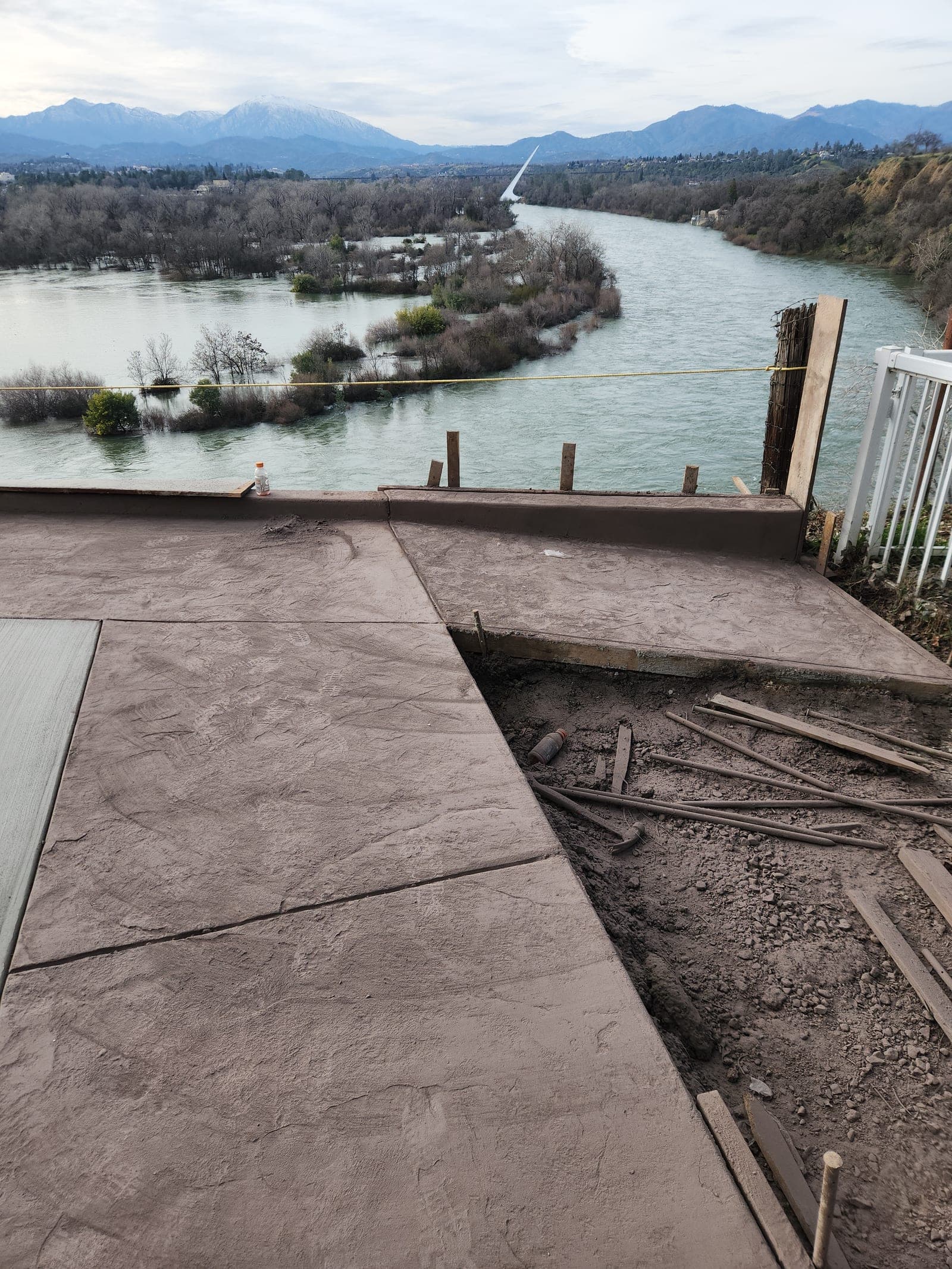 The textured border of the patio running out to the railing at the edge of the bluff
