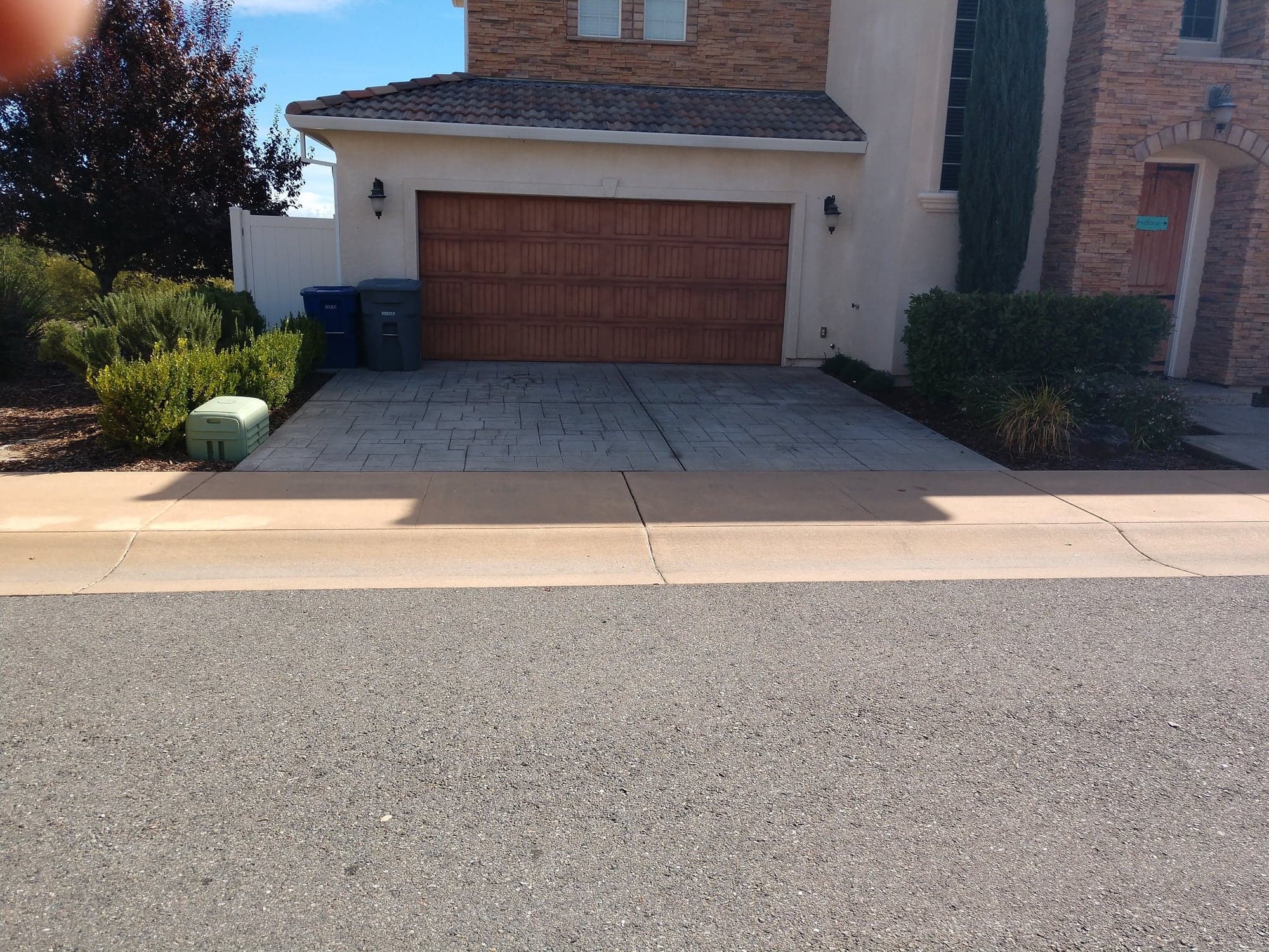 A stamped concrete driveway in front of a two-story home, seen from the street
